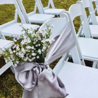 White chair with sash and flowers