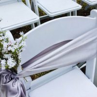 White chair with sash and flowers