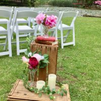 Crate with old book, candle, and flowers in vase